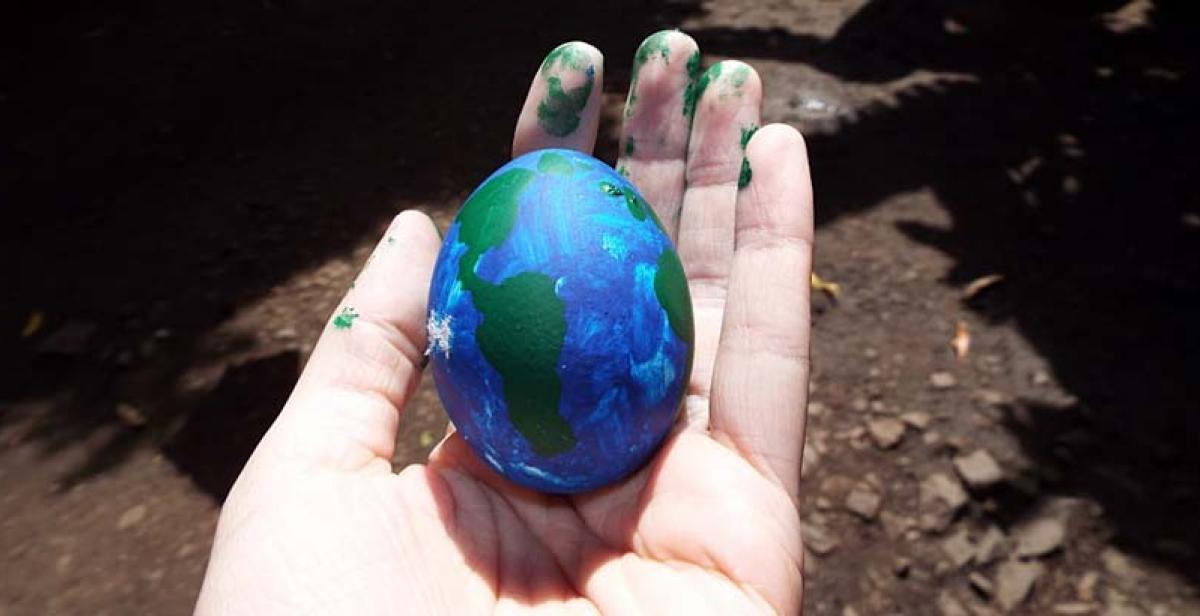  Egg painted like world in a hand