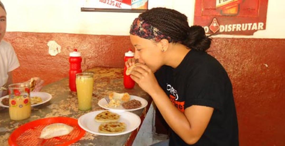 ICS volunteer Ingrid eating a pupusa