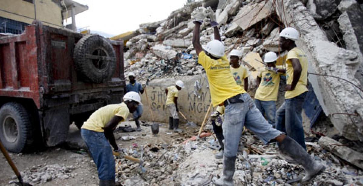 Haitians pile rubble into a waiting van