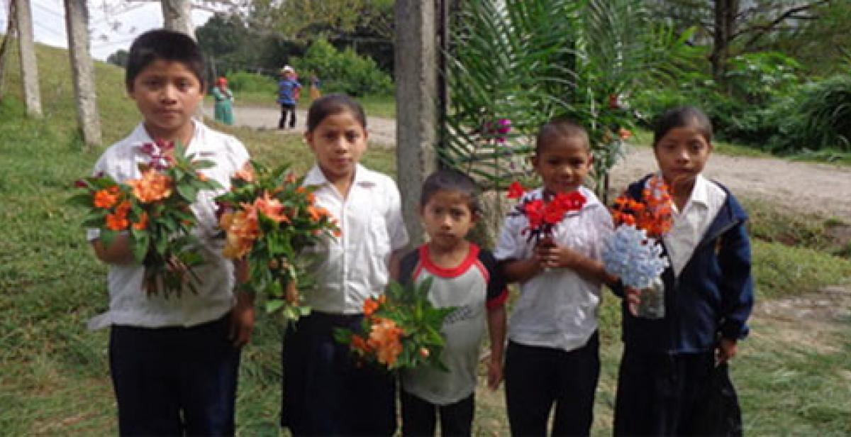 Children welcoming visitors with floweres