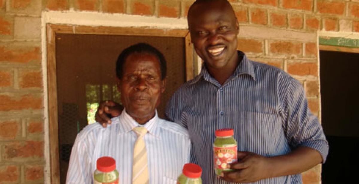 Innocent Ogaba and Mr Laston holding moringa jars
