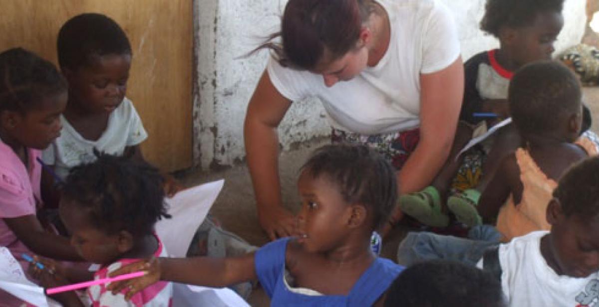 ICS volunteer Sammy drawing with children at community centre