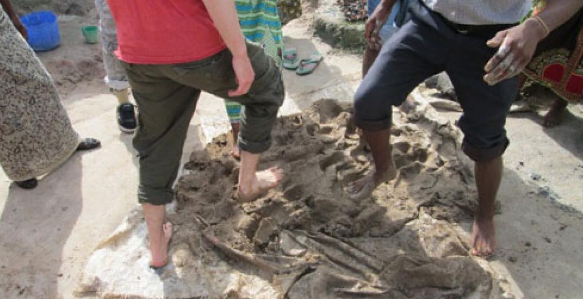 People kicking clay with their feet, Malawi
