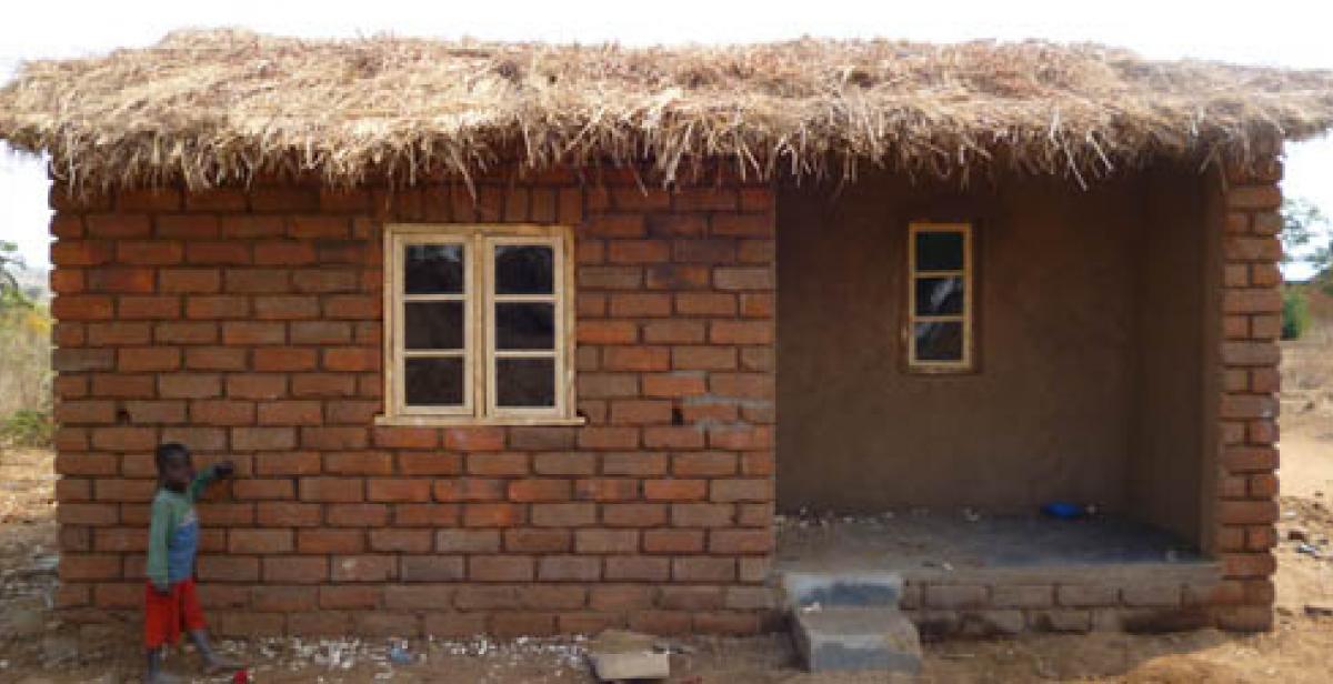 Thoko beside his house