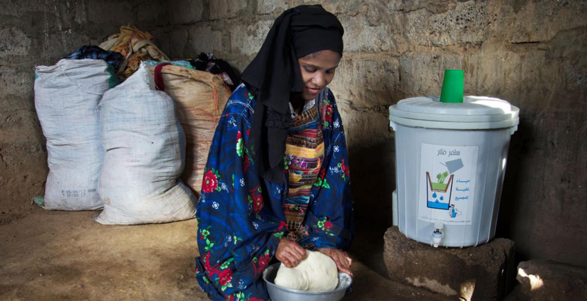 Haifa Ayash preparing dough next to a water filter, Zabid, Yemen