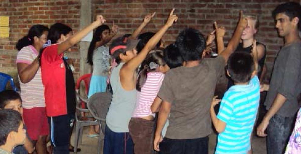 Children in English class hold up their hands