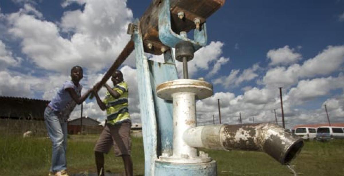 Esla Batira and Enforce Dangarembizi demonstrate how the new well and water pump