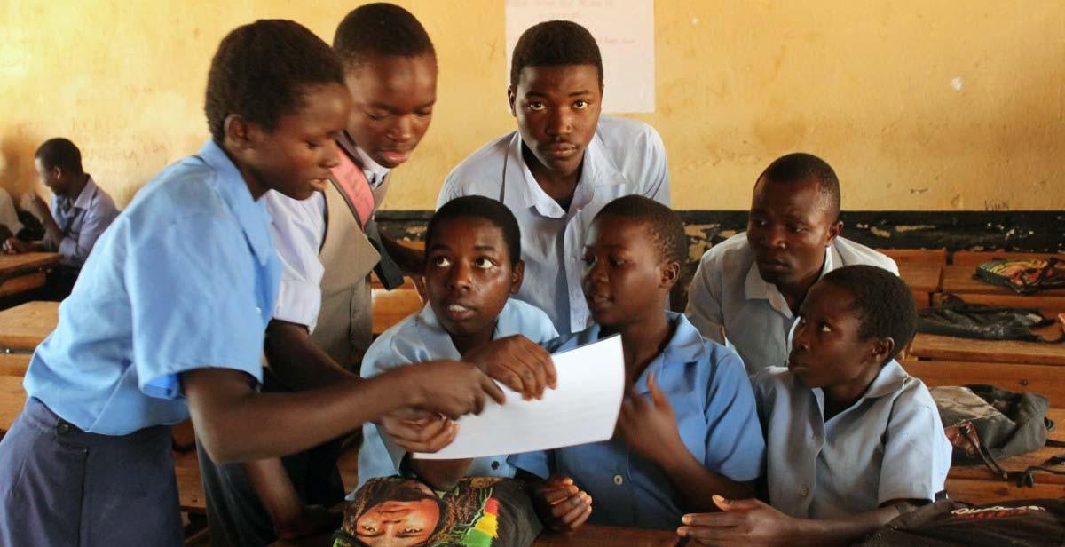 Students at Baula CDSS looking over pictures on STIs