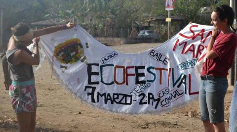 Elza and Giulia show the banner that the Eco-festival Promotion Group proudly created using cloth and other recycled materials