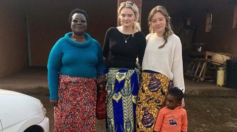 Jessica and Niamh wearing chitenjes with their host mum and host niece