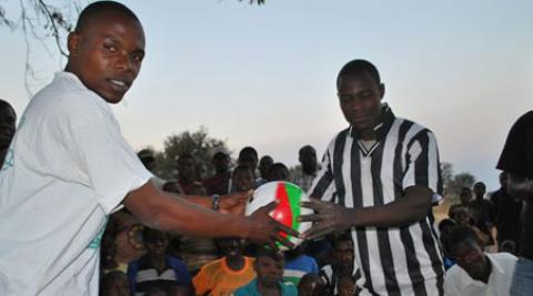 Two men holding a football in Malawi
