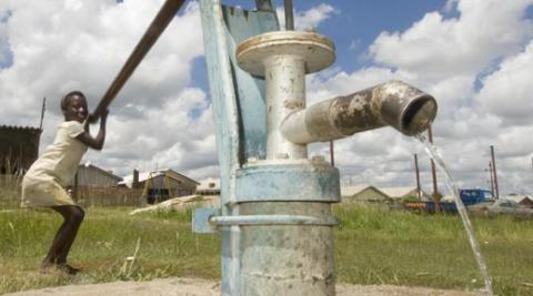 Virginia Jarusa using water pump in Zimbabwe village