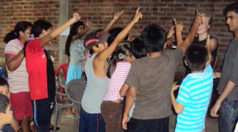Children in English class hold up their hands