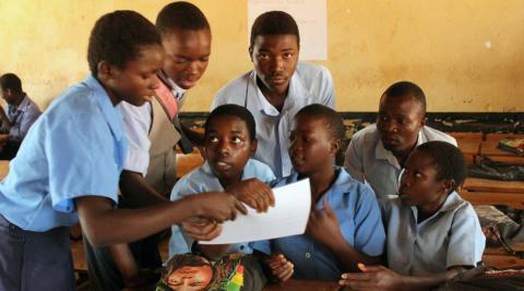 Students at Baula CDSS looking over pictures on STIs